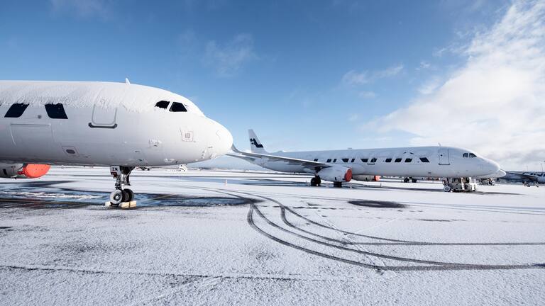 Two Finnair aircraft parked near an icy runway